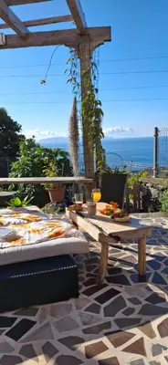 a living room with a red couch and a counter at casa2sonhos in Água de Pena