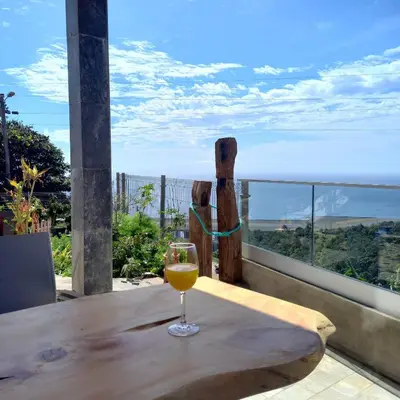 a kitchen with a refrigerator and a table with a couch at casa2sonhos in Água de Pena