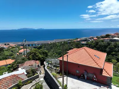 a red house with a view of the ocean at casa2sonhos in Água de Pena