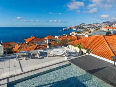 a patio with chairs and a view of the ocean at Villa Lázaro By Holiday Rental Madeira in Funchal