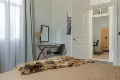 a bedroom with a bed and a desk with a fur blanket at Villa Lázaro By Holiday Rental Madeira in Funchal