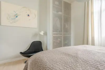 a black chair sitting next to a bed in a bedroom at Villa Lázaro By Holiday Rental Madeira in Funchal
