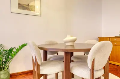 a dining room table with chairs and a vase on it at Cantinho da Elvira, a Home in Madeira in Funchal