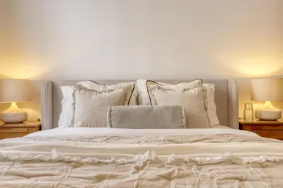a bed with white pillows and two lamps at Cantinho da Elvira, a Home in Madeira in Funchal