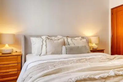 a bedroom with a large bed with white sheets and pillows at Cantinho da Elvira, a Home in Madeira in Funchal