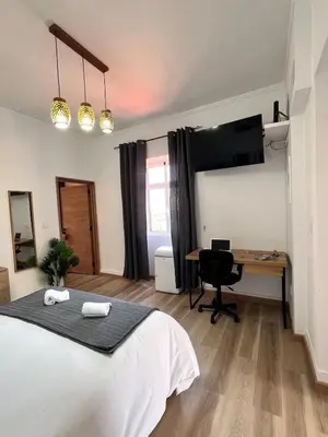 a bedroom with a bed and a desk with a computer at Bravas House 1 in Tábua