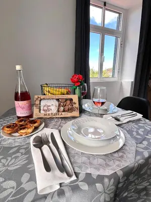 a table with a plate of food and a bottle of wine at Bravas House 1 in Tábua