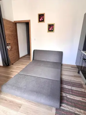 a gray bed in a room with a television at Bravas House 1 in Tábua