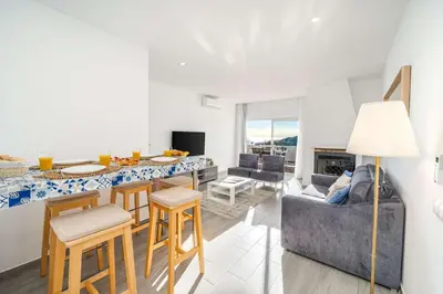 a living room with a couch and a table at Beachfront Flat & Panoramic Sea View by HostWise in Luz