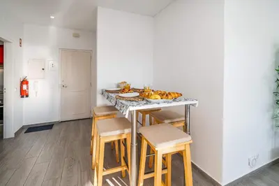 a kitchen with a counter with chairs and a table with food on it at Beachfront Flat & Panoramic Sea View by HostWise in Luz