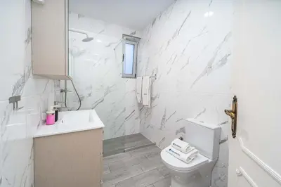 a white bathroom with a toilet and a sink at Beachfront Flat & Panoramic Sea View by HostWise in Luz