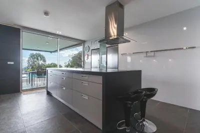 a kitchen with a counter and a stool in it at Casa Vista Azul by Atlantic Holiday in Santo da Serra