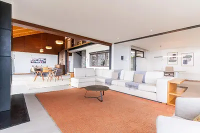 an open living room with white furniture and a table at Casa Vista Azul by Atlantic Holiday in Santo da Serra