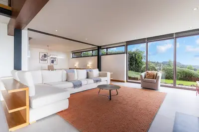 a living room with white furniture and large windows at Casa Vista Azul by Atlantic Holiday in Santo da Serra