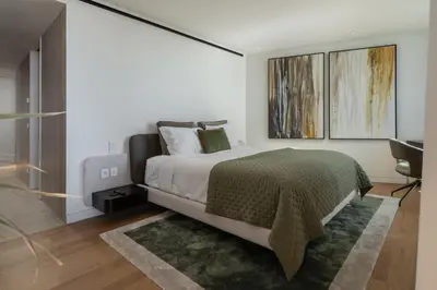 a bedroom with a bed with a green blanket at Savoy Monumentalis X by An Island Apart in Funchal