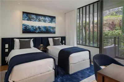 a bedroom with two beds and a balcony at Savoy Monumentalis X by An Island Apart in Funchal
