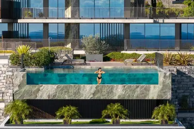 a woman standing in a swimming pool in a building at Savoy Monumentalis X by An Island Apart in Funchal