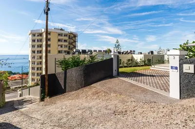 a house with a retaining wall and a building at Villa Favila by Madeira Dream Stays in Funchal