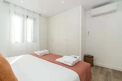 a white bedroom with two beds and a window at Villa Favila by Madeira Dream Stays in Funchal