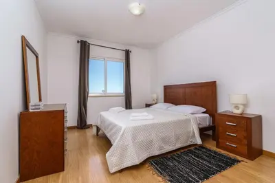 a bedroom with two beds and a large window at Atlantic View Nº3 in Caniço