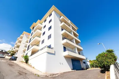 a white apartment building on a clear day at Atlantic View Nº3 in Caniço