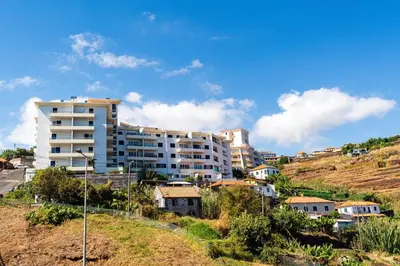 a large white building on a hill with houses at Atlantic View Nº3 in Caniço