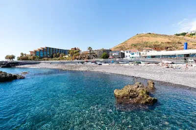 a beach with blue water and rocks in the water at Atlantic View Nº3 in Caniço