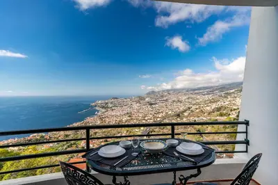 a table on a balcony with a view of the city at Atlantic Ocean by Holiday Rental Madeira in Funchal