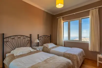 two beds in a hotel room with a window at Atlantic Ocean by Holiday Rental Madeira in Funchal