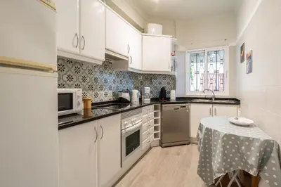 a kitchen with white cabinets and a table in it at Atlantic Ocean by Holiday Rental Madeira in Funchal
