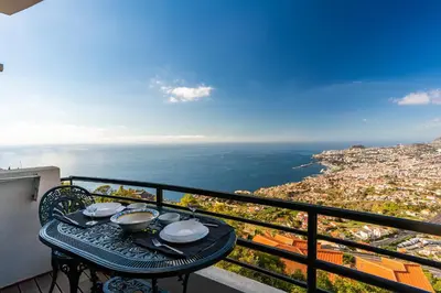 a table on a balcony with a view of the ocean at Atlantic Ocean by Holiday Rental Madeira in Funchal