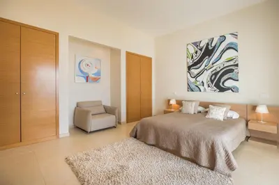 a bedroom with a large bed and a chair at Villa La Terrasse by Holiday Rental Madeira in Funchal