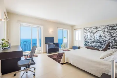 a bedroom with a bed and a desk with a computer at Villa La Terrasse by Holiday Rental Madeira in Funchal