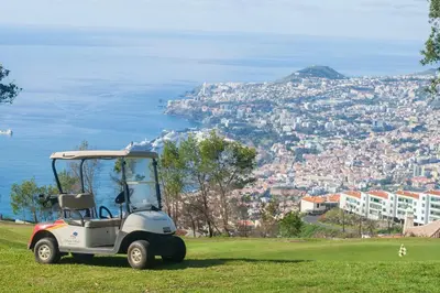 a golf cart parked on a hill with a view of the city at Villa La Terrasse by Holiday Rental Madeira in Funchal