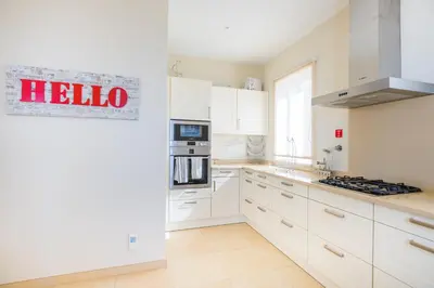 a white kitchen with a hello sign on the wall at Villa La Terrasse by Holiday Rental Madeira in Funchal