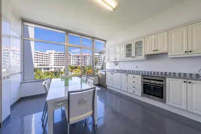 a kitchen with white cabinets and a large window at Diego Cruz Penthouse by Holiday Rental Madeira in Funchal