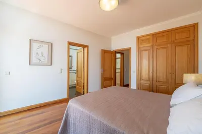 a bedroom with a bed and a wooden closet at Diego Cruz Penthouse by Holiday Rental Madeira in Funchal