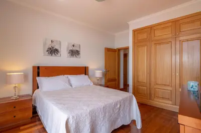 a bedroom with a bed and a wooden cabinet at Diego Cruz Penthouse by Holiday Rental Madeira in Funchal
