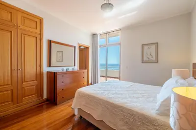 a bedroom with a bed and a view of the ocean at Diego Cruz Penthouse by Holiday Rental Madeira in Funchal