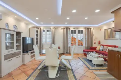 a kitchen and living room with a red couch at Oasis do Norte by Holiday Rental Madeira in São Jorge