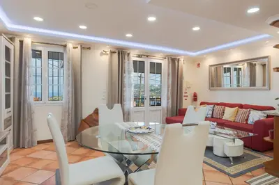 a living room with a glass table and white chairs at Oasis do Norte by Holiday Rental Madeira in São Jorge