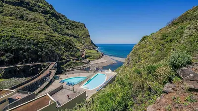 a swimming pool on a hill next to the ocean at Oasis do Norte by Holiday Rental Madeira in São Jorge