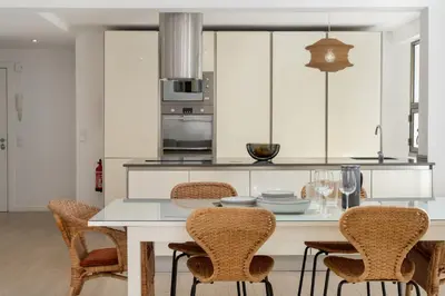 a kitchen with a white table and chairs at Baía II by An Island Apart in Funchal