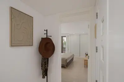 a white room with a bed and a door to a bedroom at Baía II by An Island Apart in Funchal
