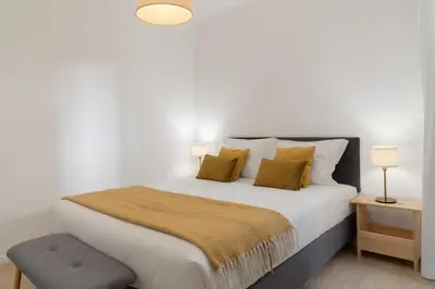 a bedroom with a large bed with yellow pillows at Baía II by An Island Apart in Funchal