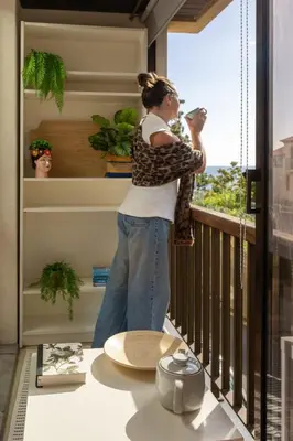 a woman standing on a balcony taking a picture of a window at Baía II by An Island Apart in Funchal