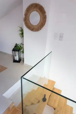 a glass staircase in a house with a wreath on the wall at tiny BEACH HOUSES - 2 min to Beach in Salema