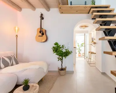 a living room with a guitar hanging on the wall at tiny BEACH HOUSES - 2 min to Beach in Salema