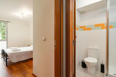 a bathroom with a bed and a toilet in a room at New Santa Cruz Airport & Downtown Apartment in Santa Cruz