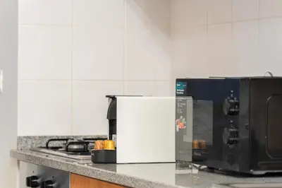 a kitchen counter with a microwave and a refrigerator at New Santa Cruz Airport & Downtown Apartment in Santa Cruz